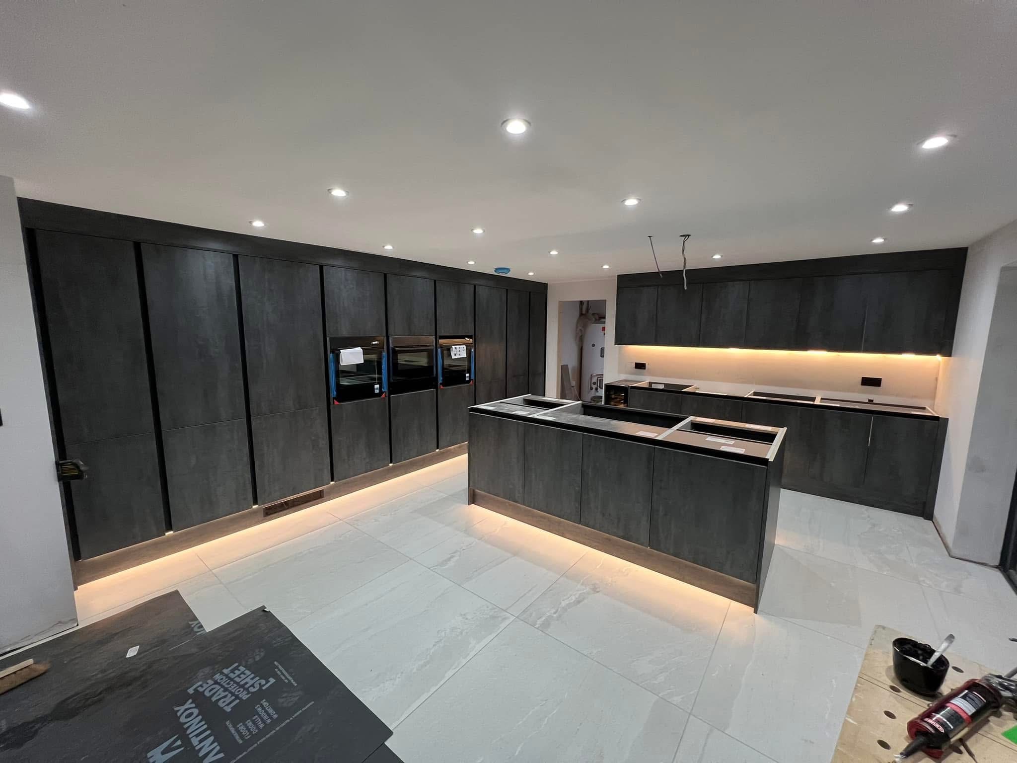 Contemporary dark fitted kitchen with island and integrated lighting