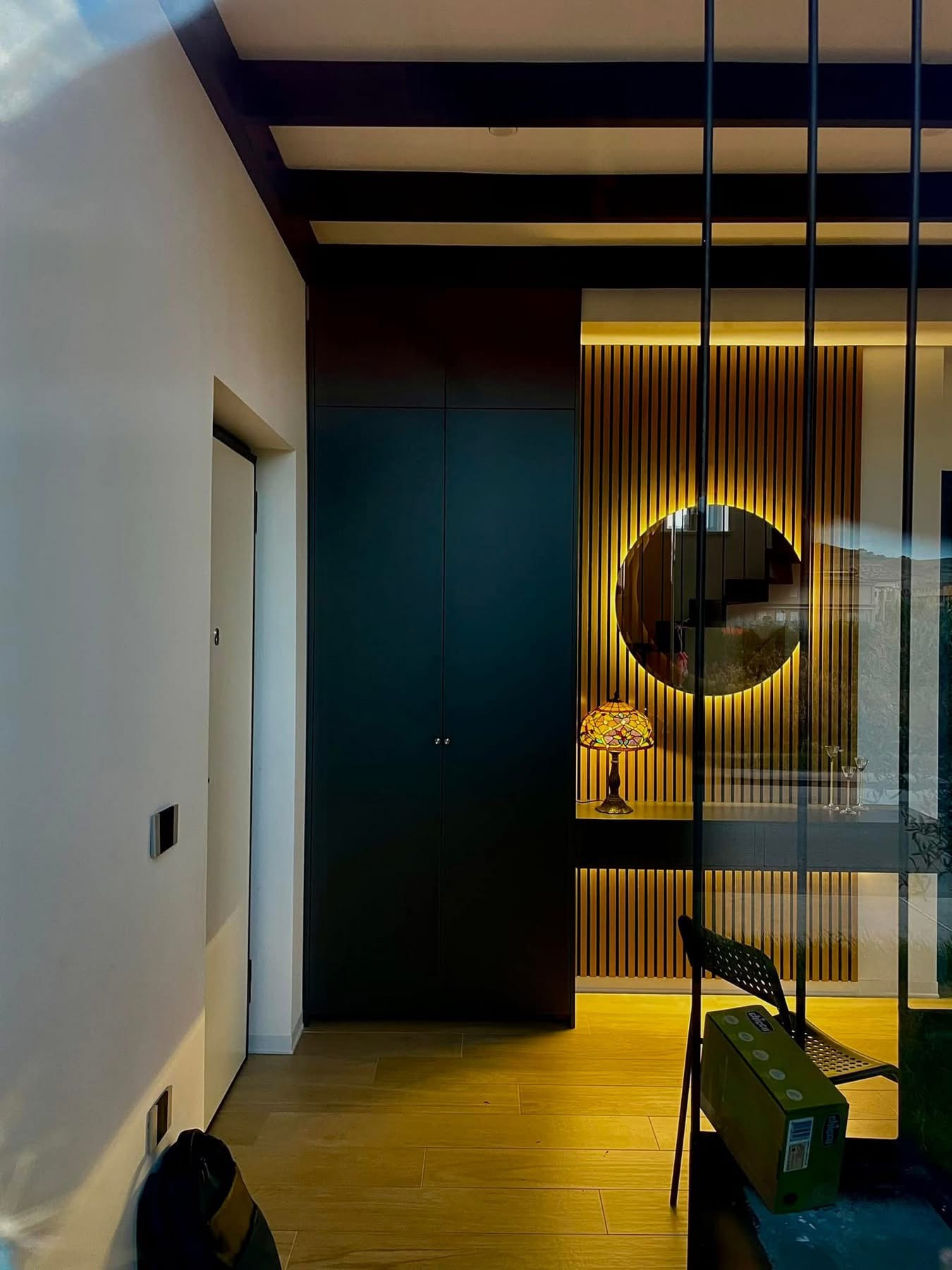Illuminated timber slat feature wall with round mirror and floating console